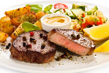 Grilled steak, baked potatoes and vegetables