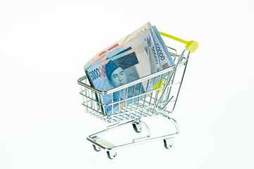 Indonesian Rupiah in shopping cart over white background