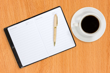 Notebook and coffee cup on the table