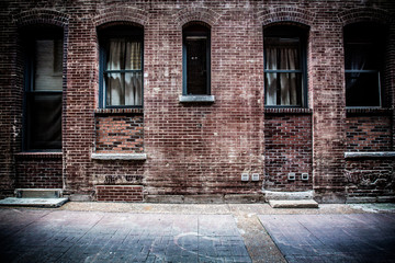 Fototapeta na wymiar Old brick alleyway with metal doors and windows
