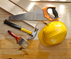 wood floor with a brush, saw, hammer and helmet