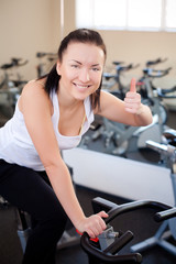 Fototapeta premium beautiful woman on an exercise bike at the gym 