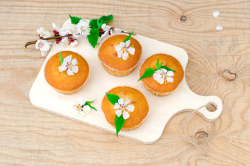 Muffins with jam on a wooden table with flowers