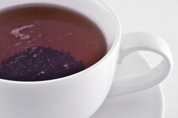 white cup with black tea