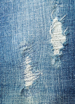 blue jean texture with a hole and threads showing