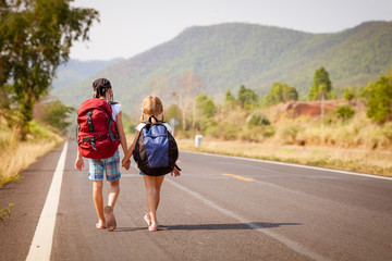 Fototapeta premium two little girls with backpack walking on the road