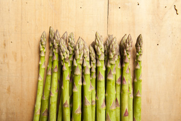Bunch of fresh green asparagus on wooden background