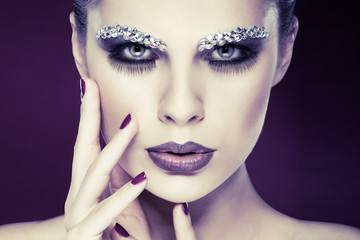 sexual beautiful girl with strasses on face, on a violet 