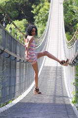 Pretty young woman on the suspension bridge