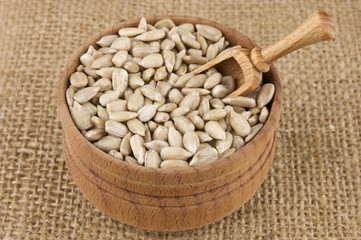 Shelled raw sunflower seeds in wooden bowl on burlap