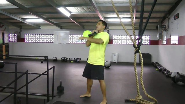 Athlete doing kettlebell clean and press crossfit exercise.