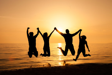 Fototapeta na wymiar Four friends jumping on the beach