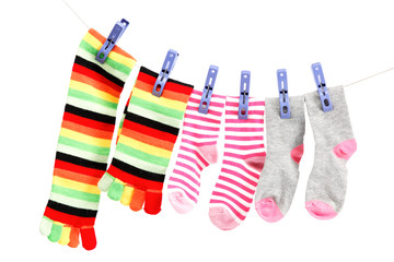 Colorful socks on a rope against white background.