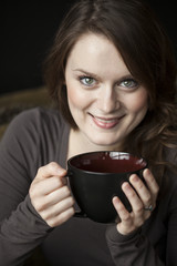 Young Woman with Beautiful Green Eyes and Black Coffee Cup