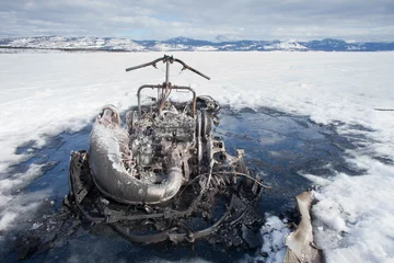 Fotobehang Bizarre burnt out snowmobile on Yukon lake Canada © PiLensPhoto