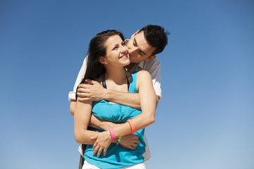 Beautiful couple kissing on blue sky background