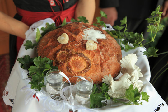 Chleb s&oacute;l i w&oacute;dka na przywitanie młodej pary.