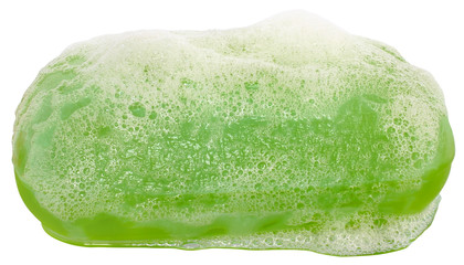 Bar of green soap in the foam close up.