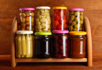 Different conservations on shelves on wooden background