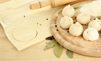 Raw dumplings and dough, on wooden table