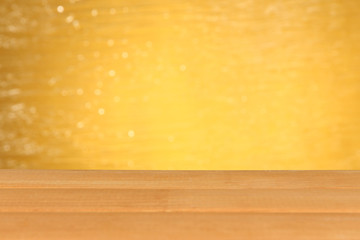 Wooden table on yellow background