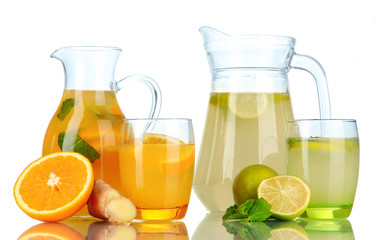 Orange and lemon lemonade in pitchers and glasses isolated
