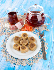 Sweet baklava on plate with tea on table