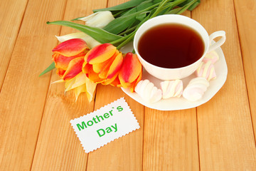 Composition of tulips and cup with some drink,