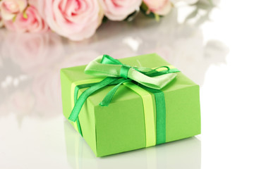 Beautiful gift on flowers background isolated on white