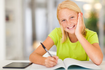 happy teen schoolgirl doing homework