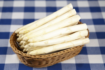 Obraz premium Korb mit Spargel auf einer karierten Tischdecke