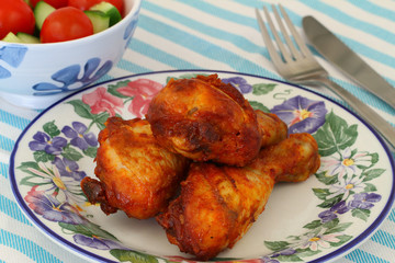 Roasted chicken drumsticks on vintage plate
