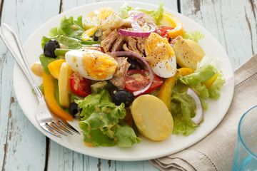 nicoise salad over blue wood background