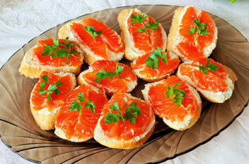 Salted red pieces of salmon on a bread with butter