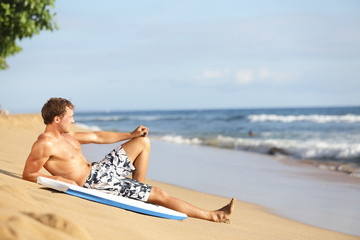 Beach man relaxing after surfing