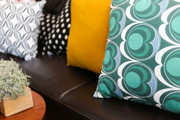 Close-up of colorful pillows on a leather sofa