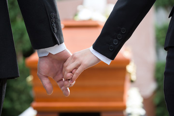 People at funeral consoling each other - obrazy, fototapety, plakaty