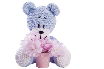 blue teddy bear stuffed animal with pink blossom in a bucket