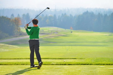 Golfer swing, teeing off on beautiful summer morning