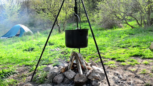 Pot boiling on fire. Fireplace in the forest.