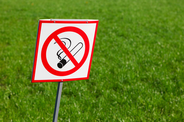 No smoking sign on green grass background