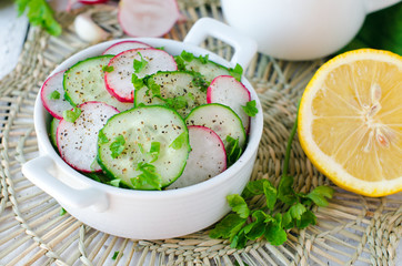 Salad from fresh cucumbers , radish