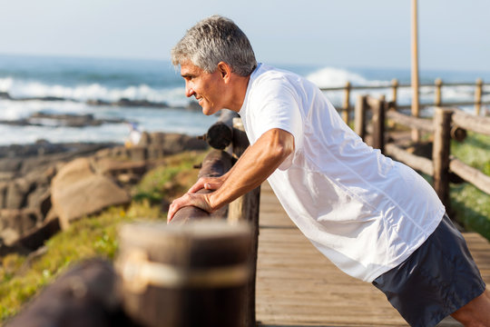 fit senior man exercising at the beach