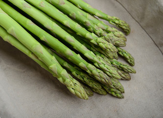 fresh green asparagus sprouts laying on bamboo background