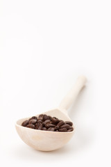 wooden spoon with coffee beans, isolated on white