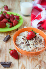 oatmeal in a bowl with milk and strawberries,
