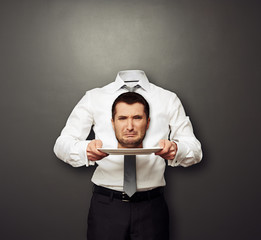headless man holding crying head on white plate