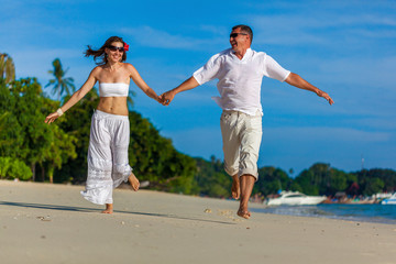 running couple on a tropical beach