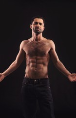 Shirtless Man on Dark Background Gesturing