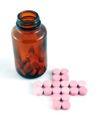 Cross shape pills and a bottle on white background